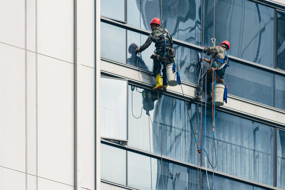 A person in personal protective equipment vacuuming indoors, ensuring a thorough clean.